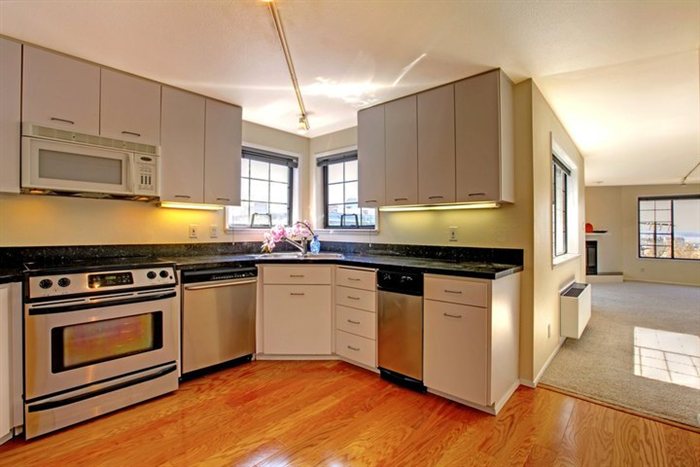 Clean condo kitchen with stainless appliances